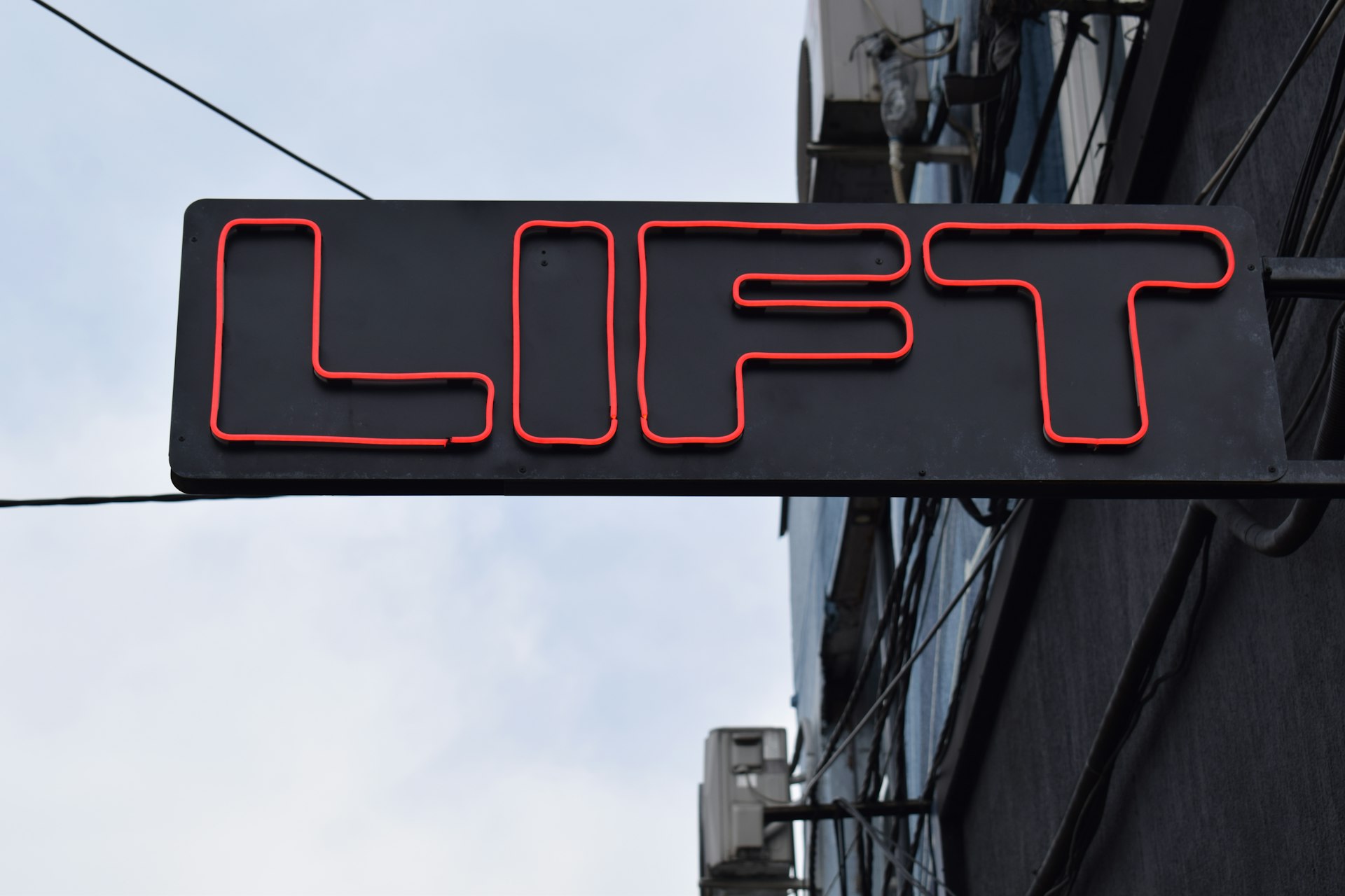 a neon sign that says lift above a building